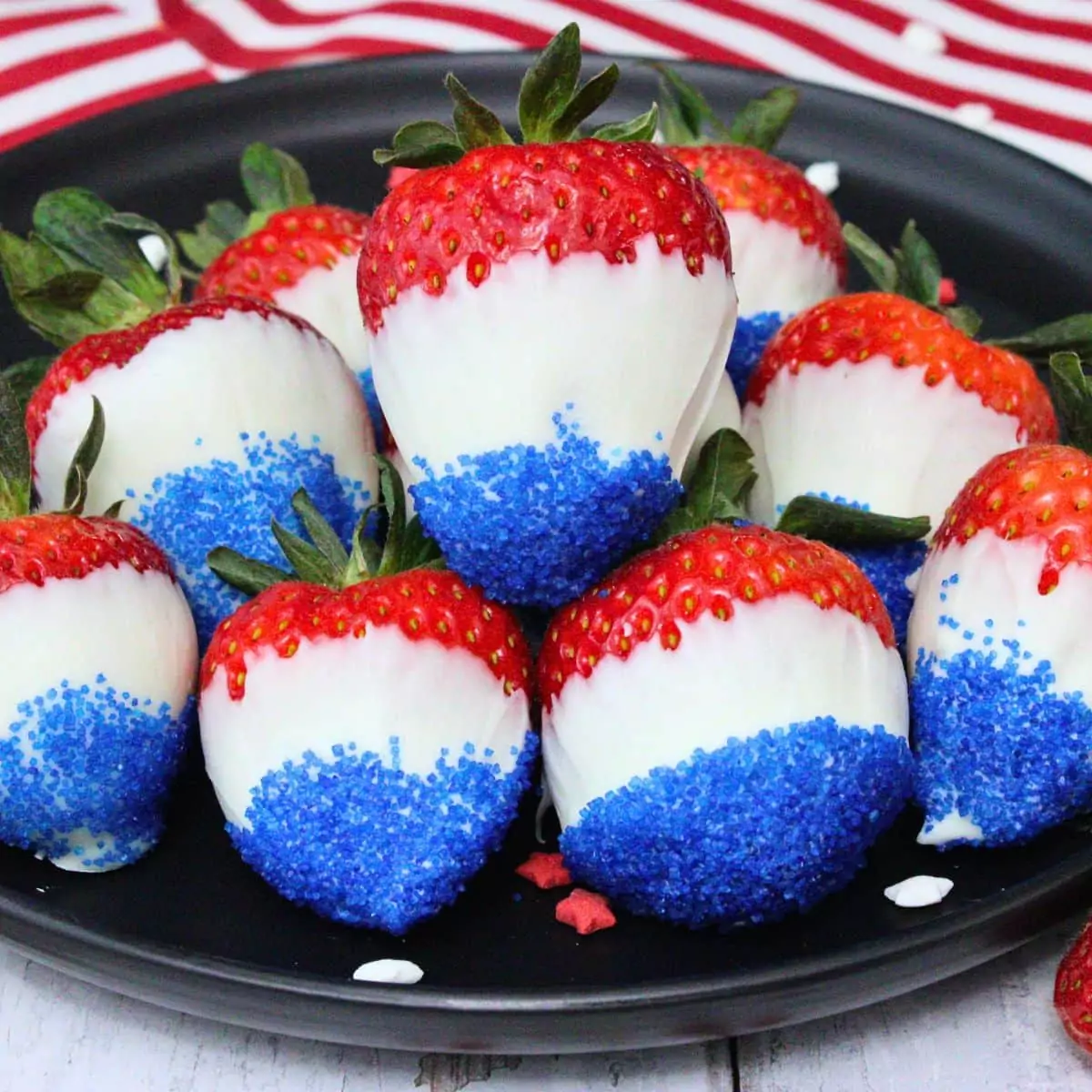 Red, white, and blue chocolate-covered strawberries with sugar coating.