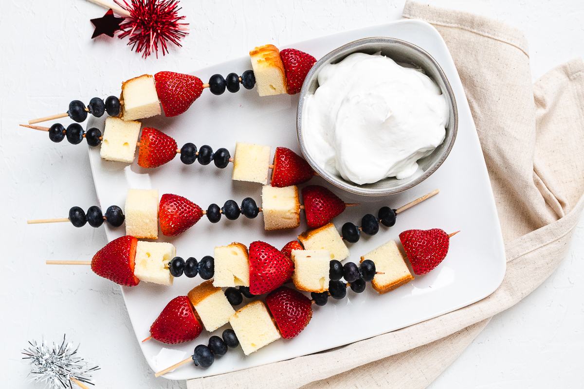 Overhead image of red, white, and blue pound cake skewers.