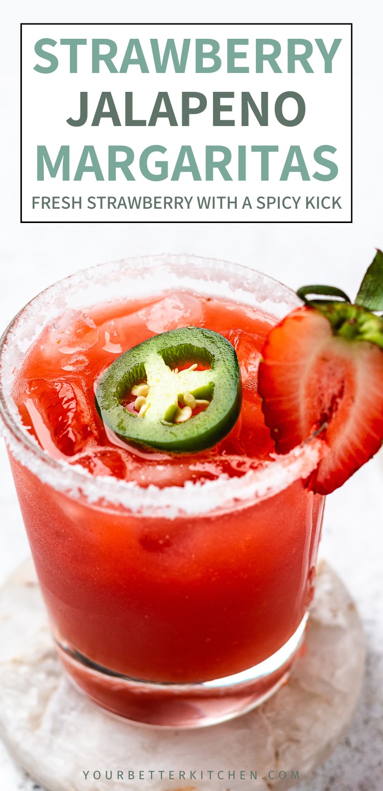 Glass of red margarita with ice, salted rim, jalapeรฑo slice, and strawberry with text that reads Strawberry Jalapeno Margaritas fresh strawberry with a spicy kick.