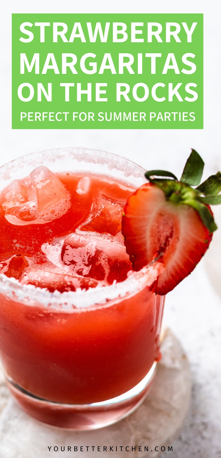 Glass of red strawberry margarita with ice and a strawberry slice with text that says Strawberry Margaritas on the Rocks perfect for summer parties.
