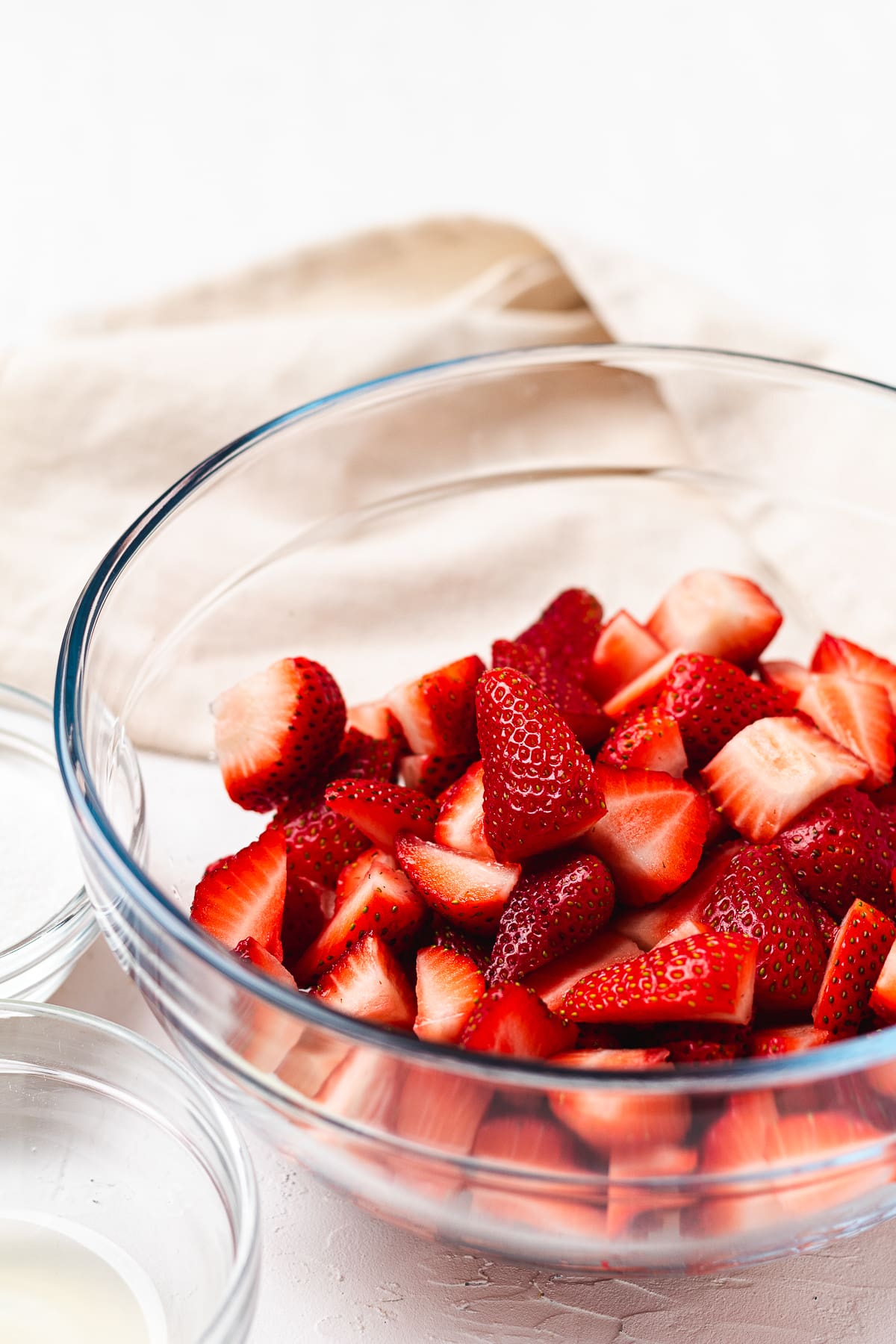 Chopped strawberries in a clear bowl ready to be mixed for shortcake topping.