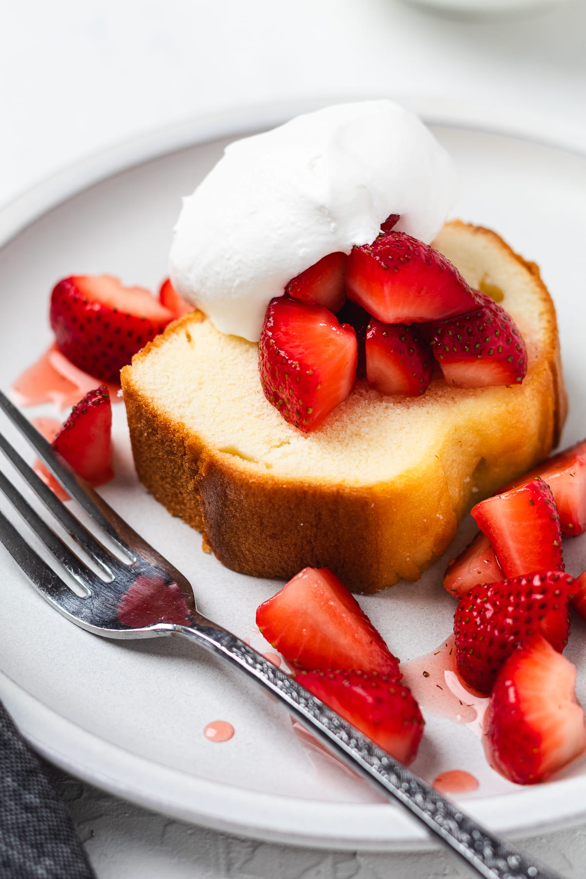 Strawberry shortcake with pound cake with chopped strawberries on a light plate.