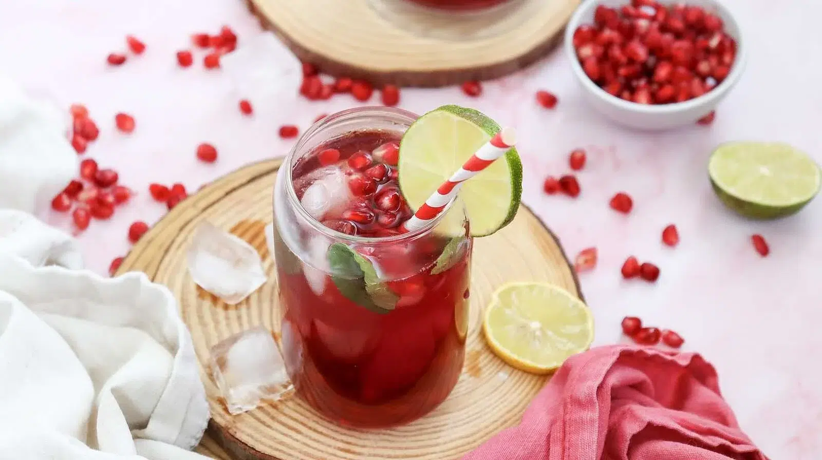 Pomegranate mocktail with ice, fresh mint, lime, and pomegranate seeds.