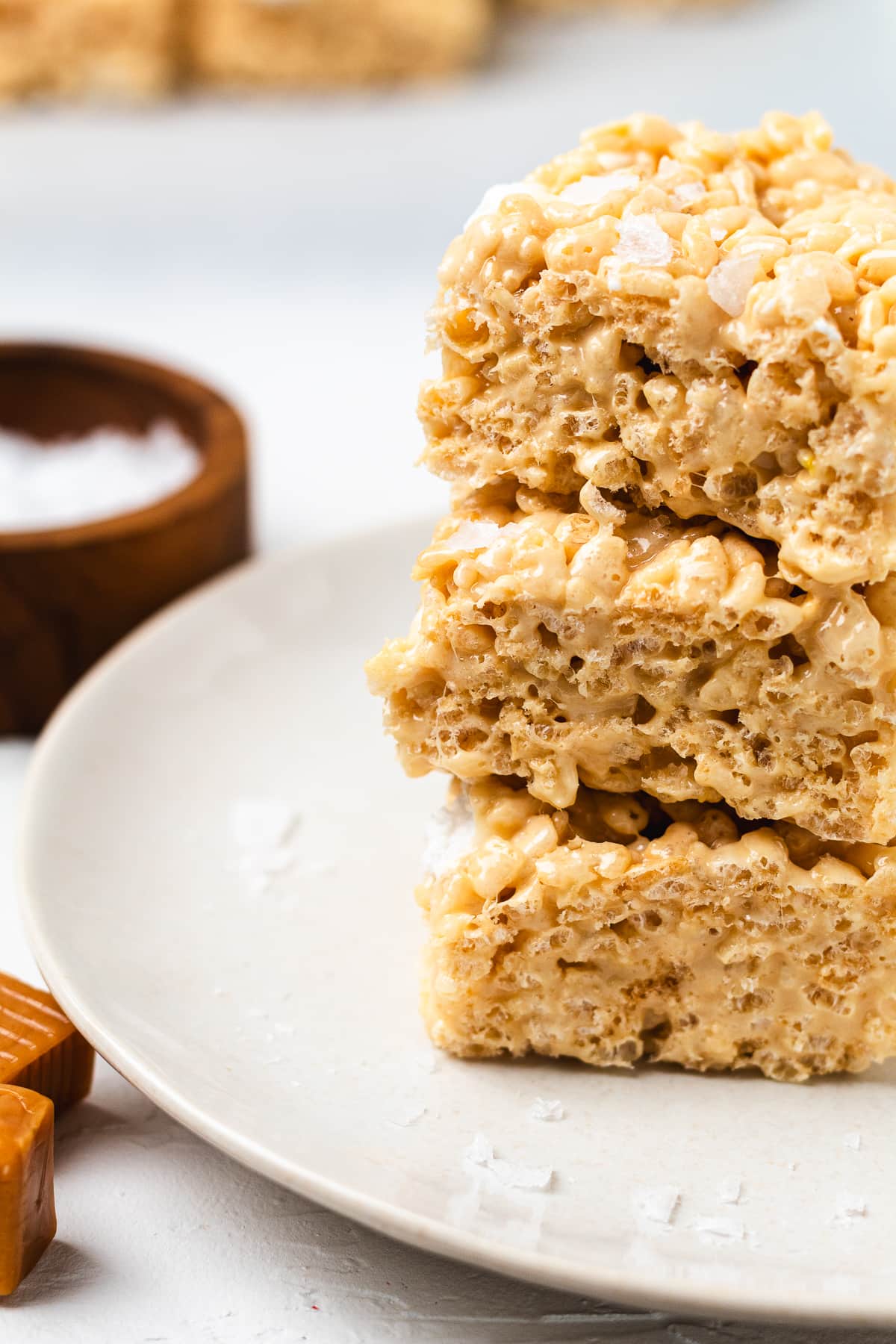 Stack of salted caramel Rice Krispie treats on a white plate.