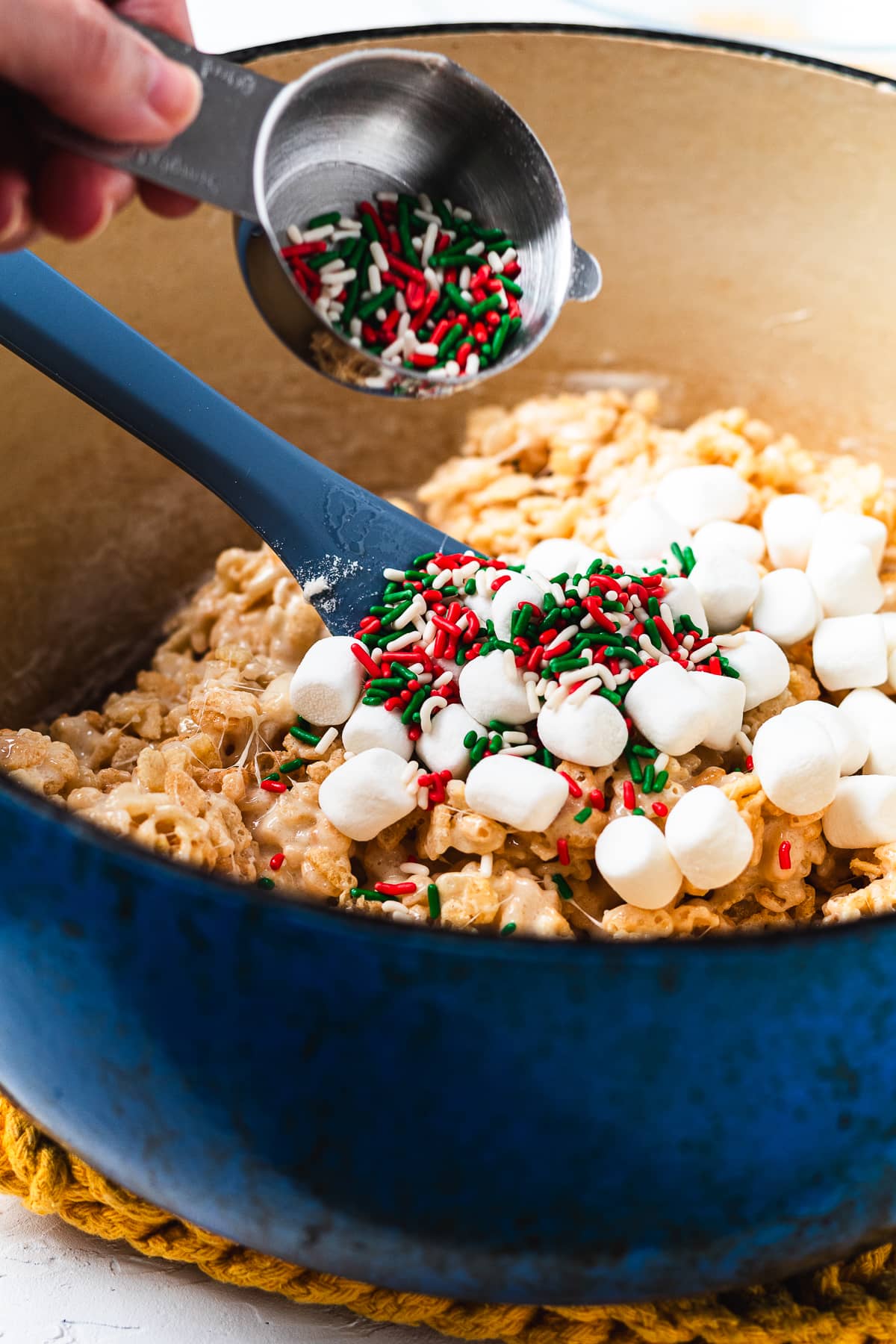 Adding sprinkles and marshmallows to Rice Krispie treats.