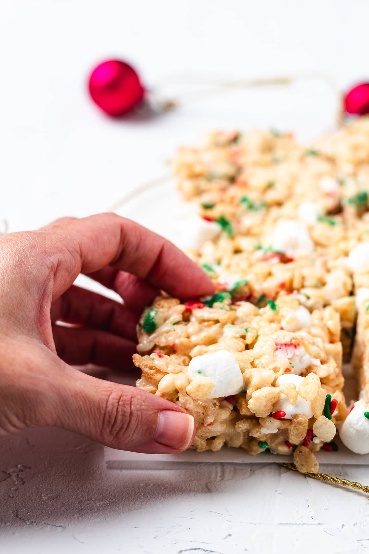 Hand holding a Christmas sugar cookie Rice Krispie treat.