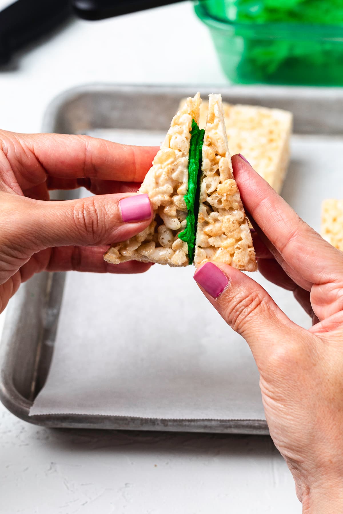 Pressing Rice Krispie treat triangles together.