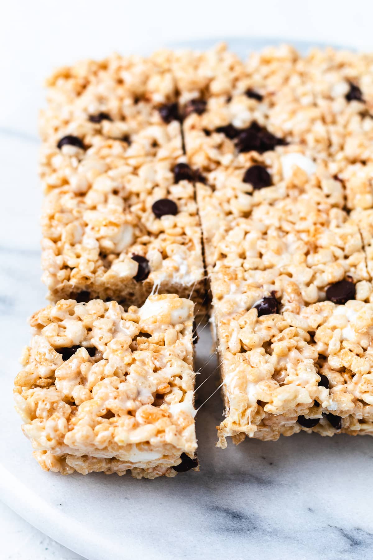 Brown butter Rice Krispie treats with chocolate chips on a marble board.