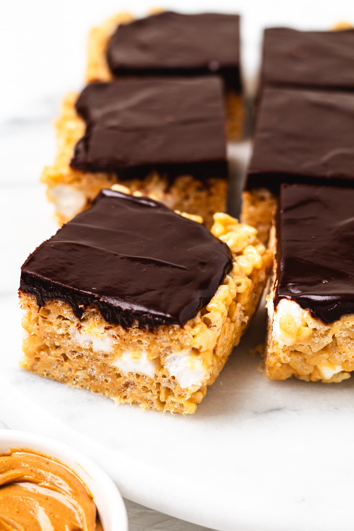 Chocolate peanut butter Rice Krispie treats topped with chocolate ganache and cut into squares.