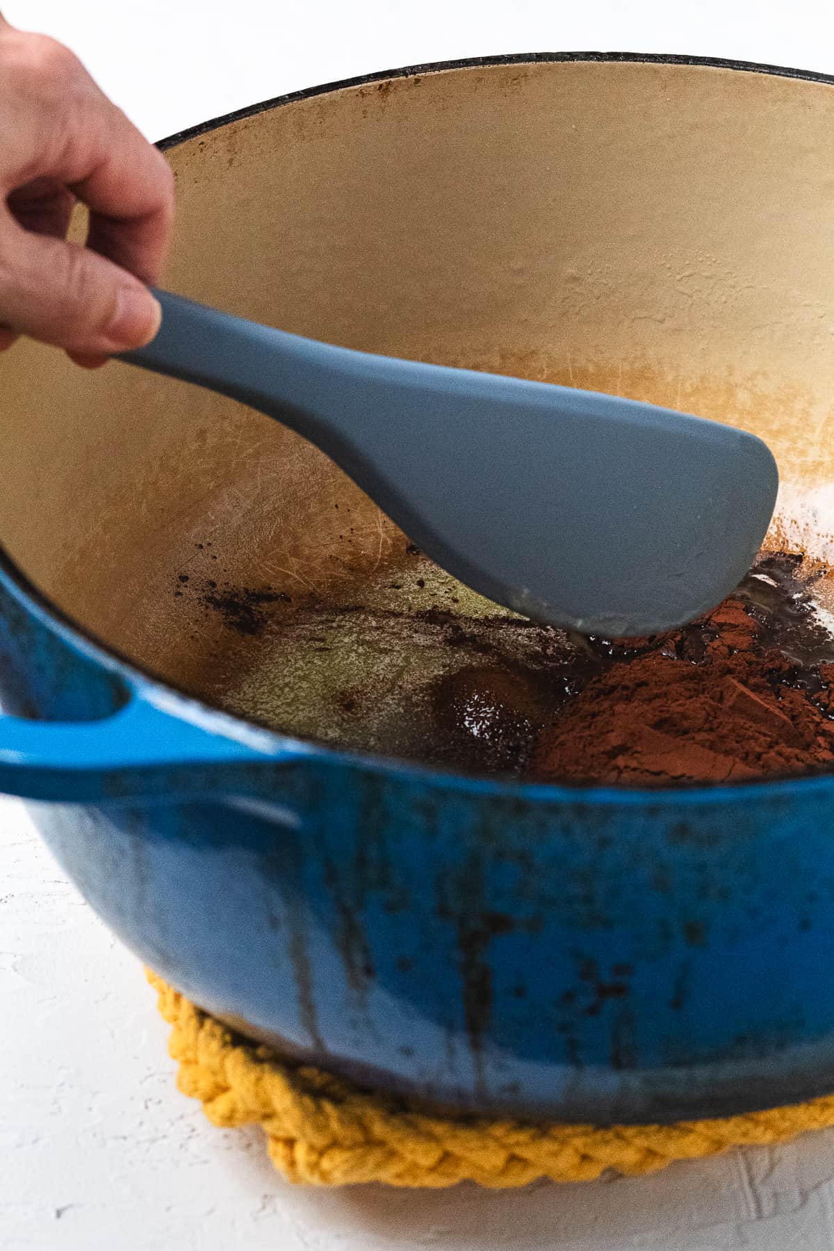Mixing butter and cocoa powder in a pot.