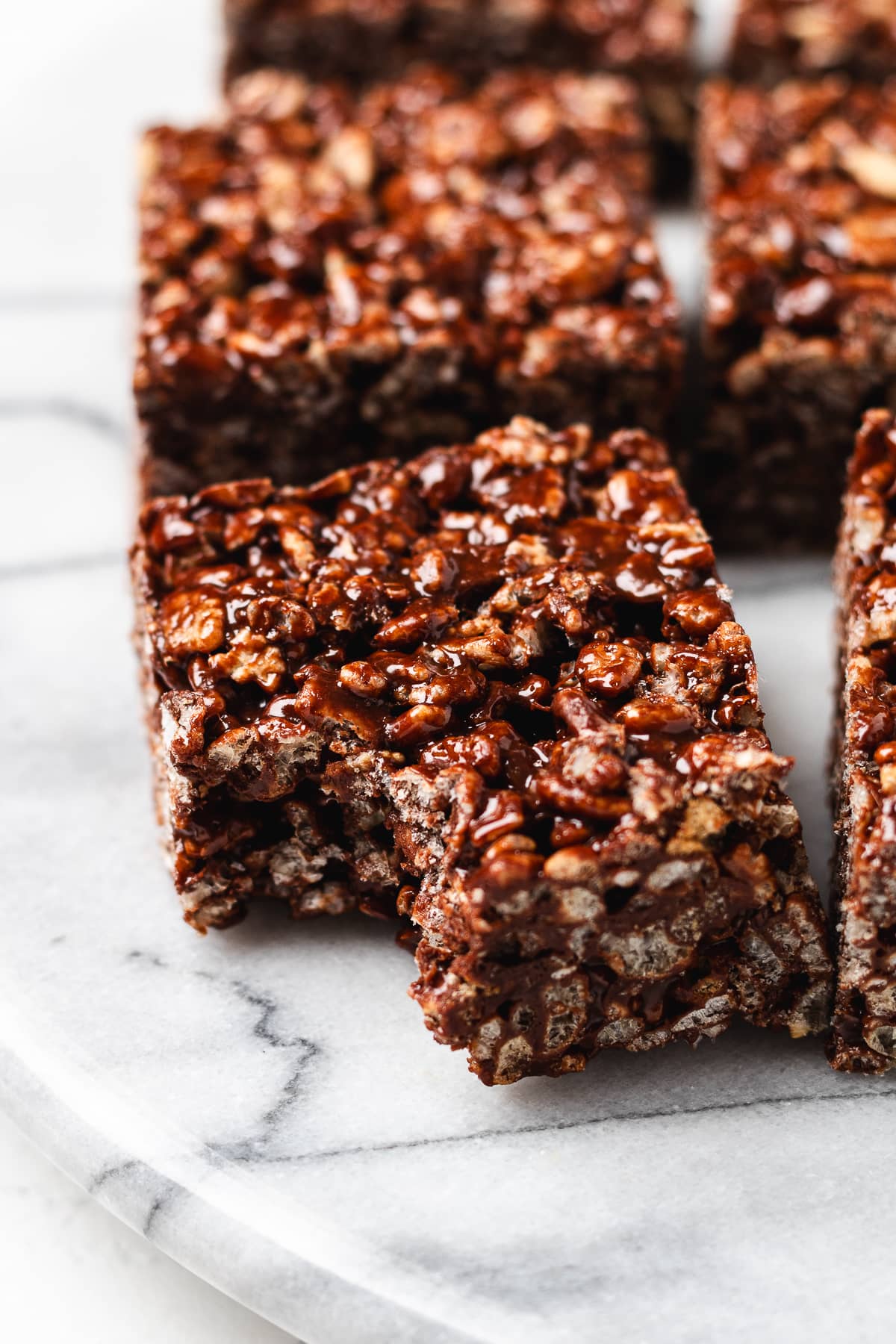 Chocolate Rice Krispie treats on a marble board.