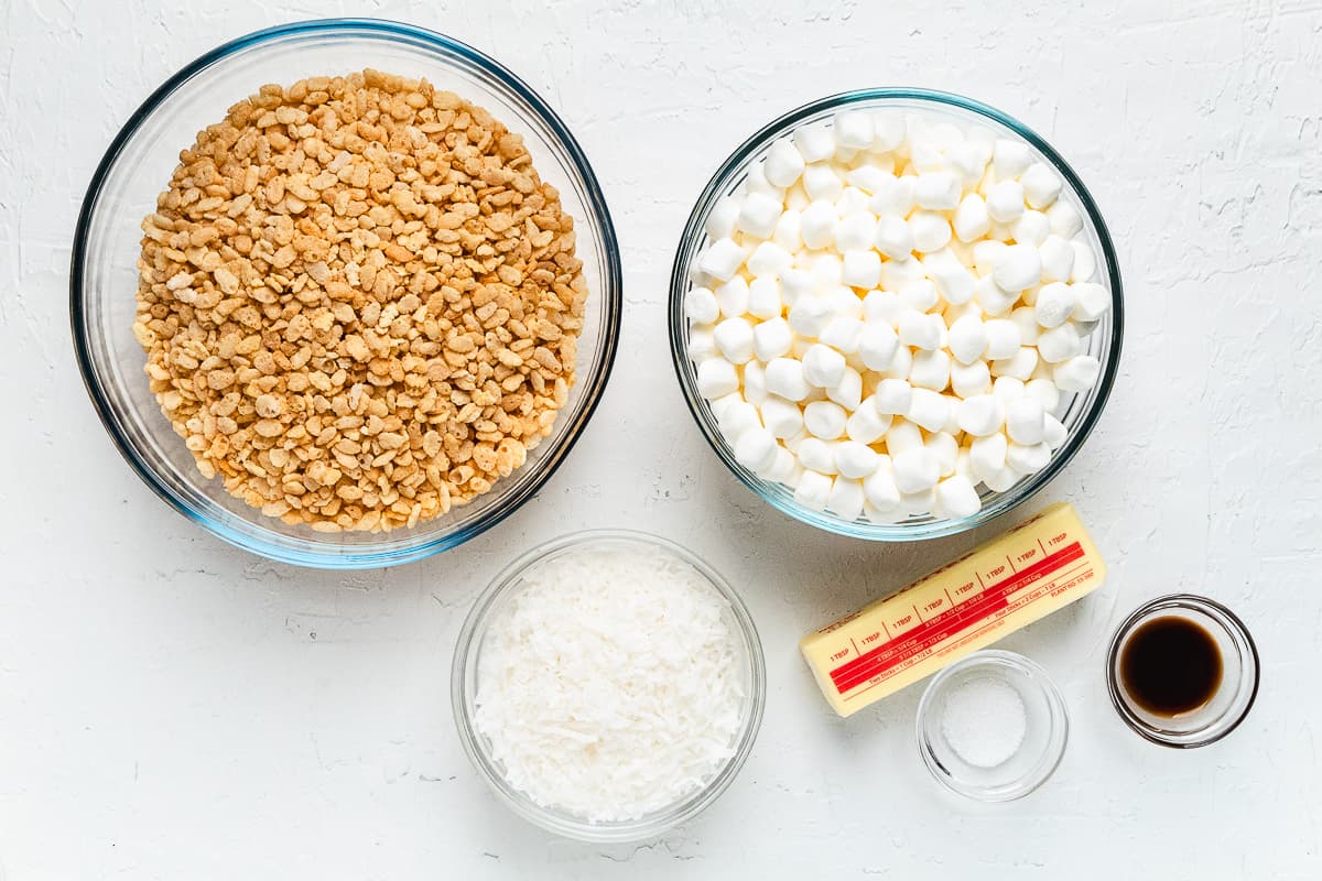 Ingredients for coconut Rice Krispie treats measured in glass bowls.