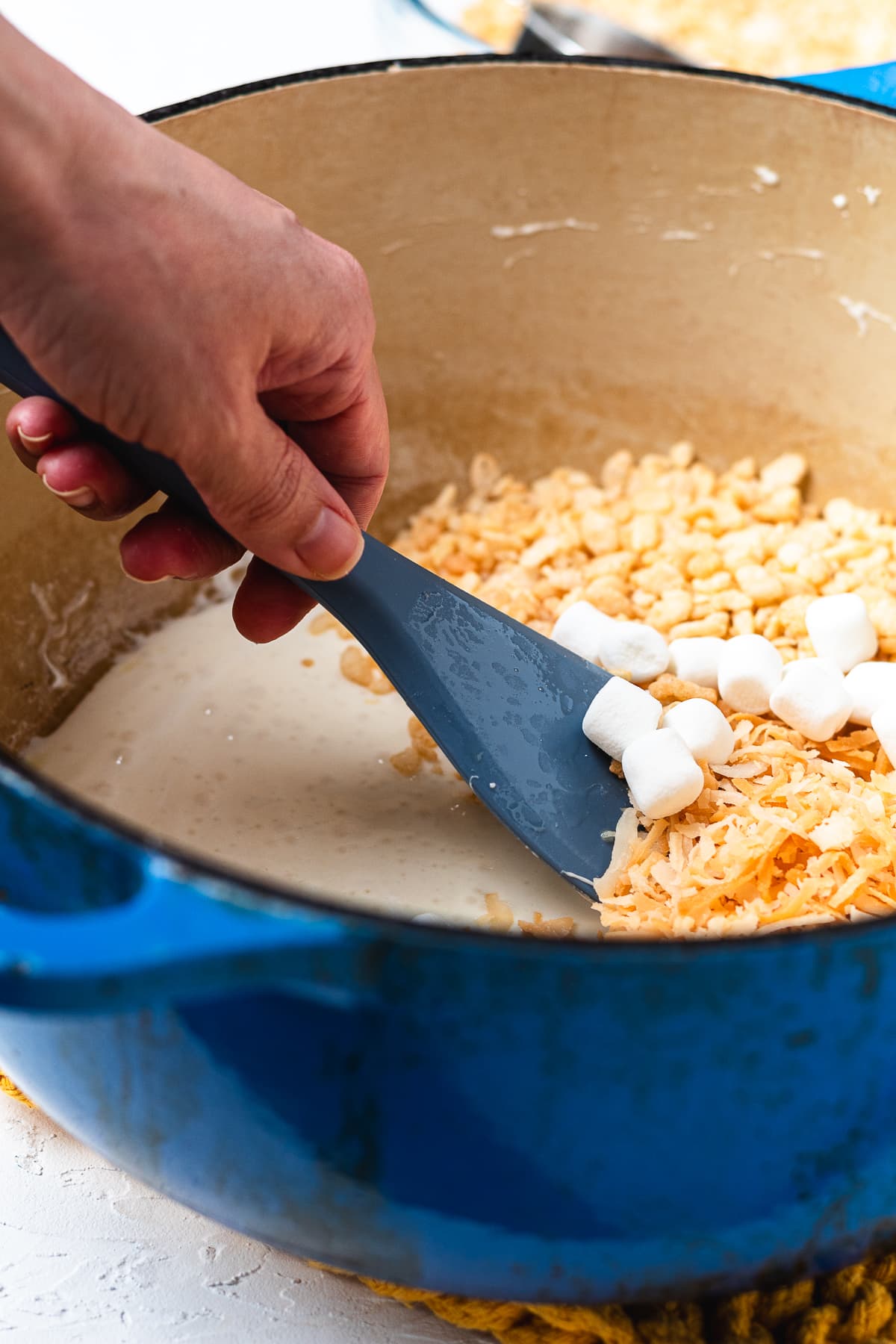Mini marshmallows added to Rice Krispies and toasted coconut mixture.
