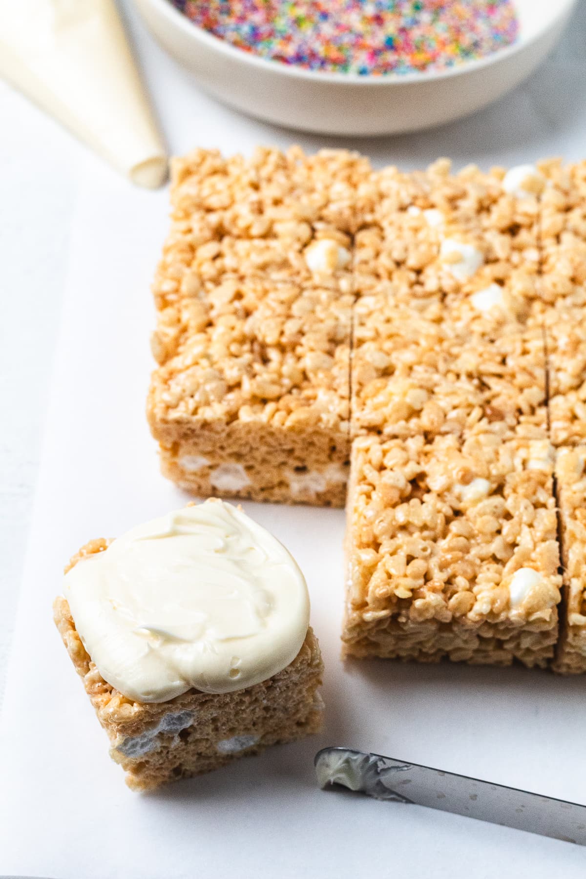 Rice Krispie treat topped with white frosting.