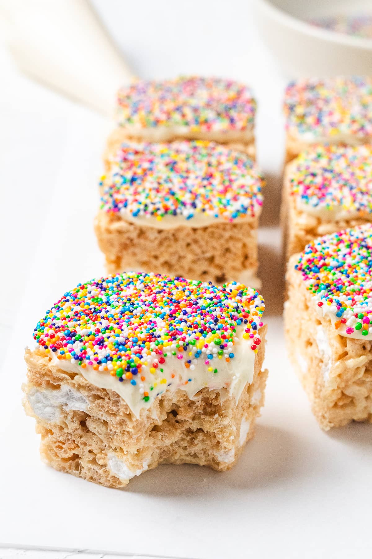 Dot Cake Rice Krispie treat topped with frosting and rainbow dot sprinkles.
