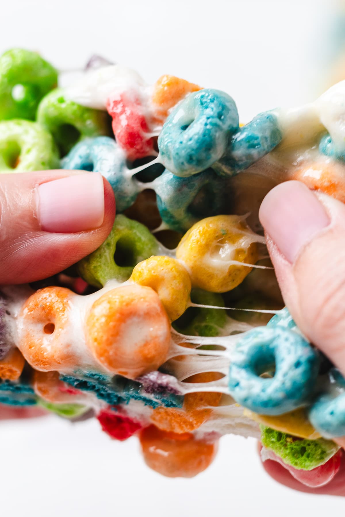 Pulling apart gooey Froot Loops Rice Krispie Treats.
