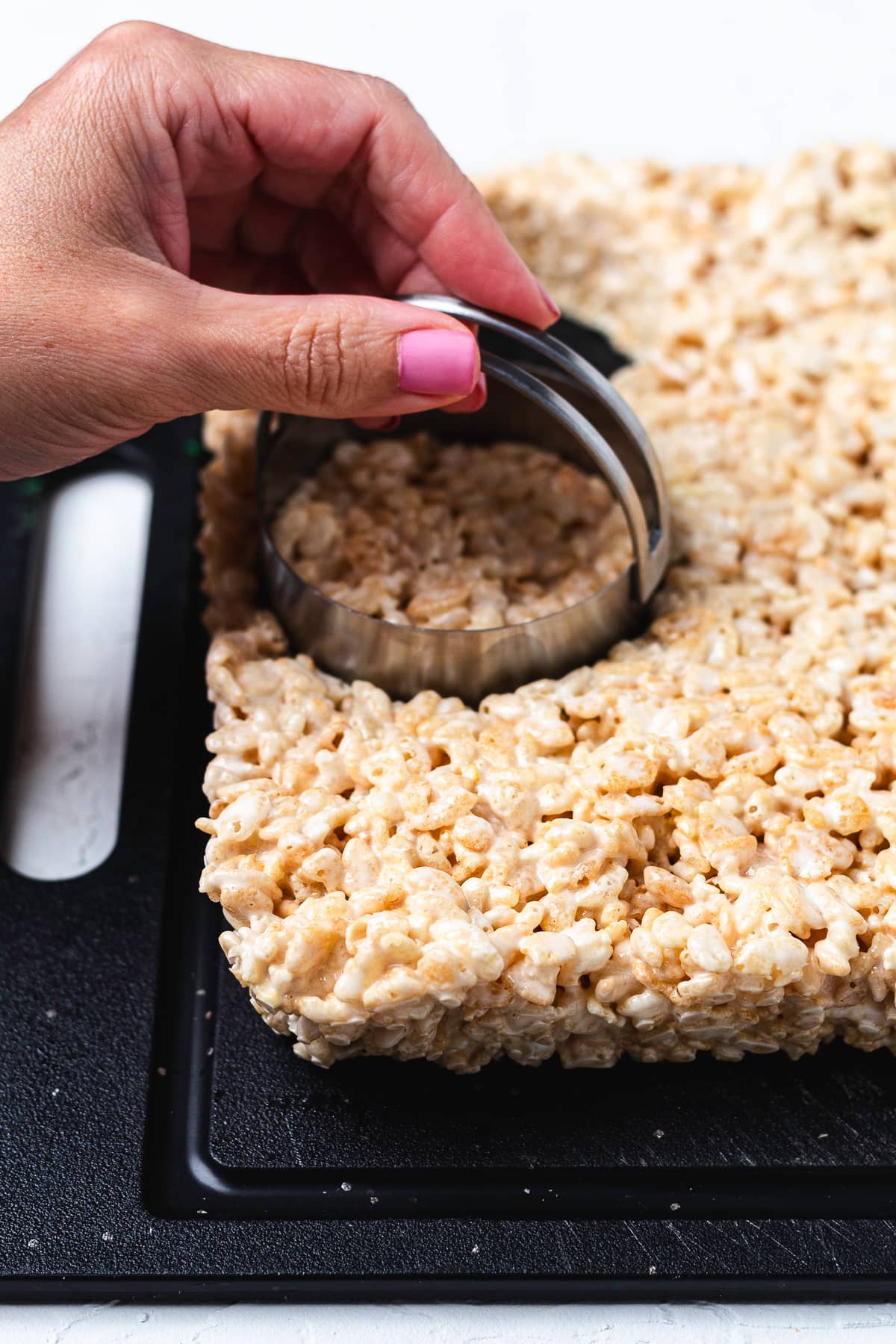 Cutting circles from Rice Krispie treats with a round cookie cutter.