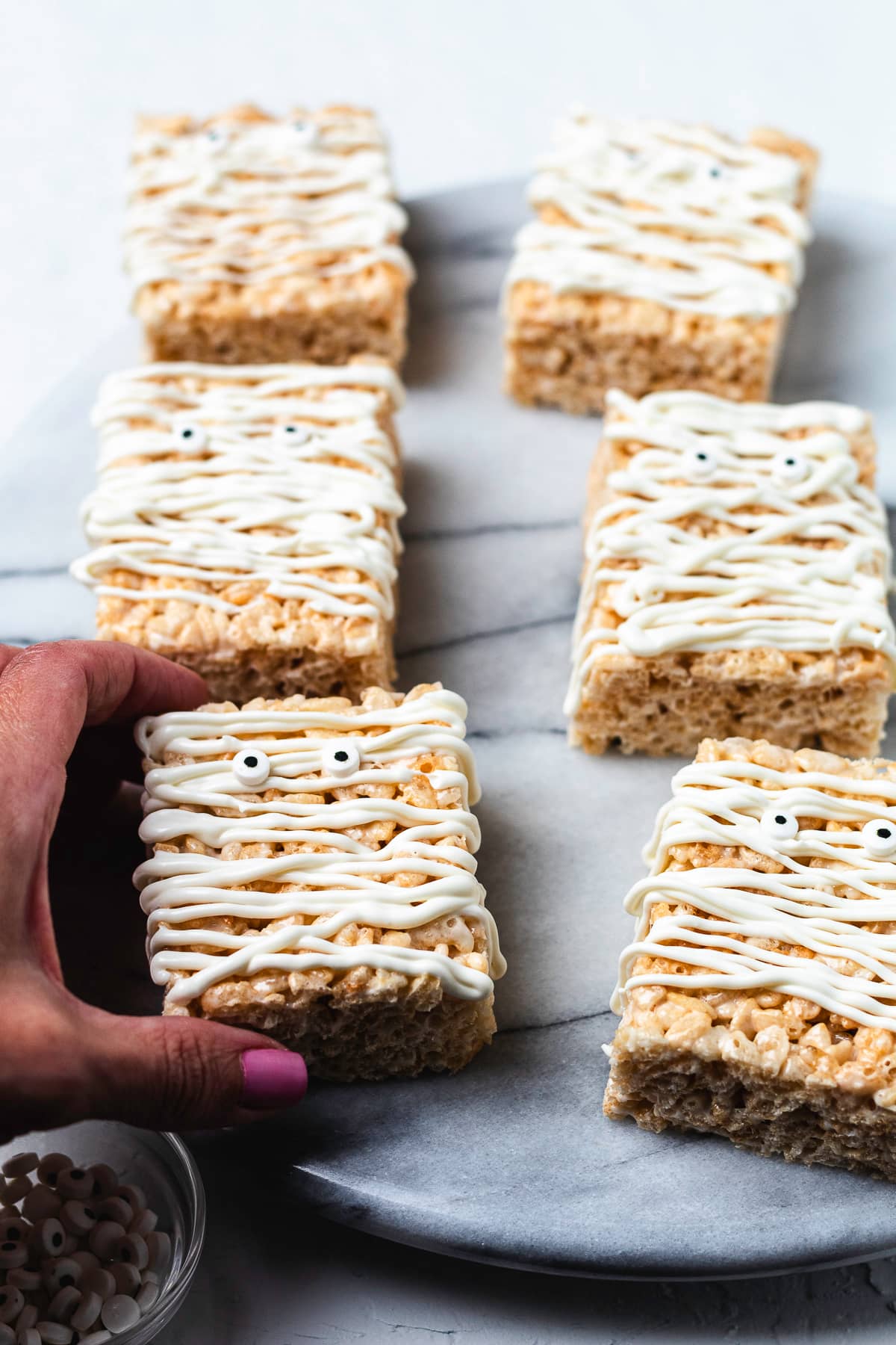 Mummy Rice Krispie treats on marble serving board.
