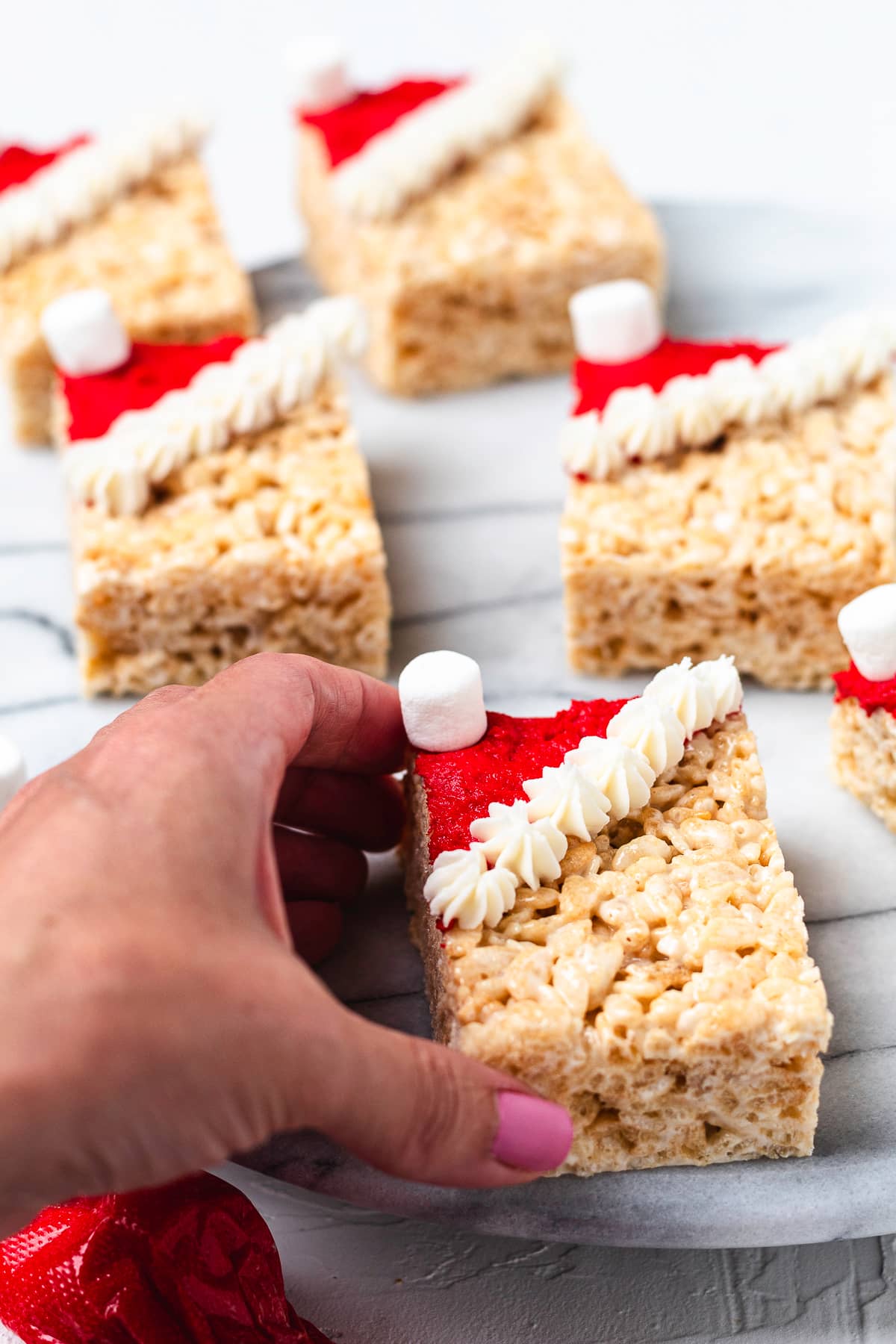 Hand holding a Santa hat Rice crispy treat.