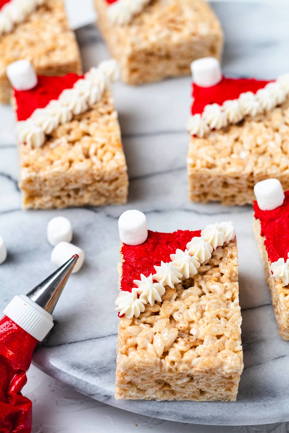 Santa hat Rice Krispie treats on a marble serving board.
