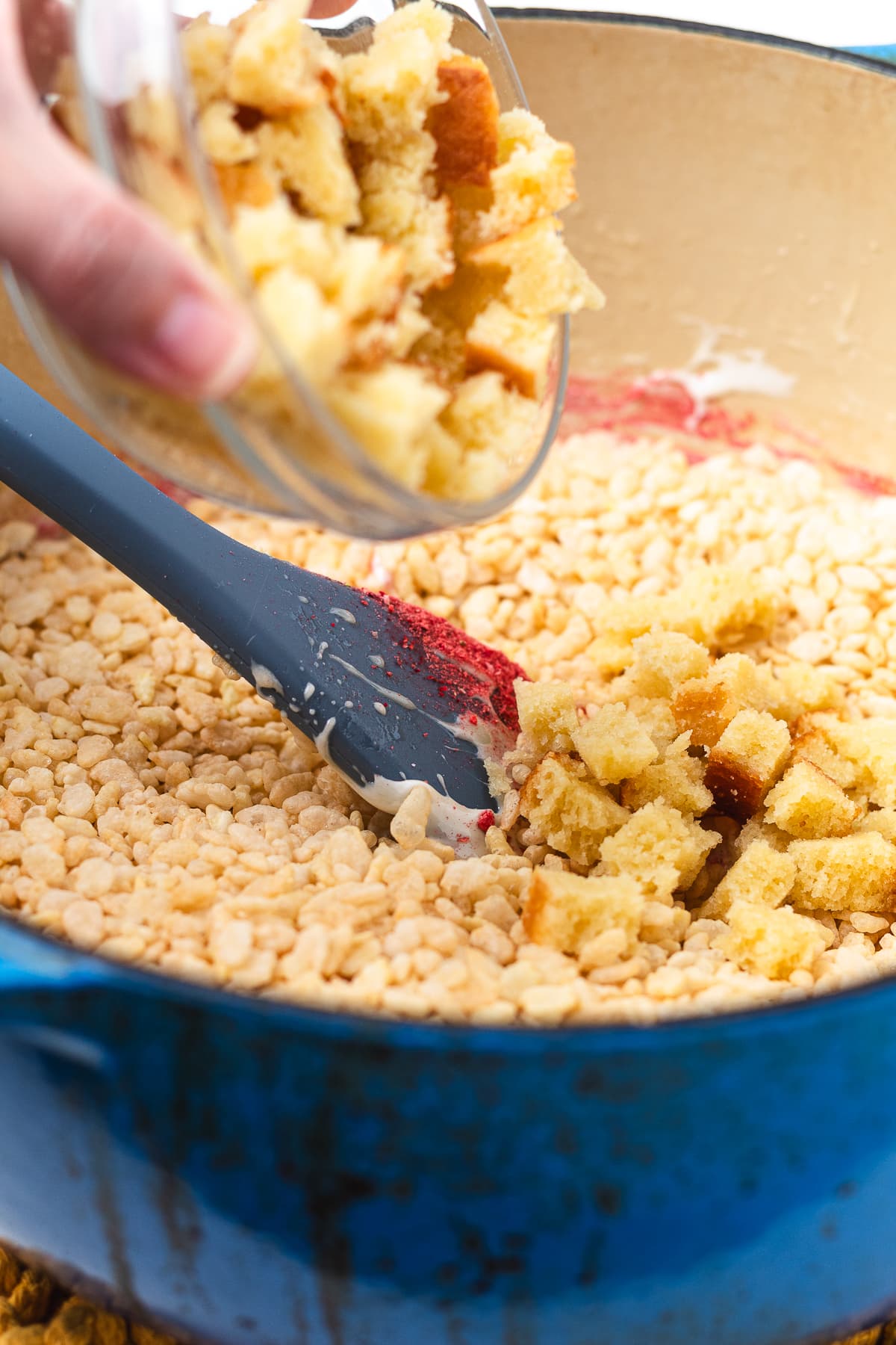 Adding pound cake cubes to Rice Krispie cereal mixture for strawberry shortcake Rice Krispie treats.