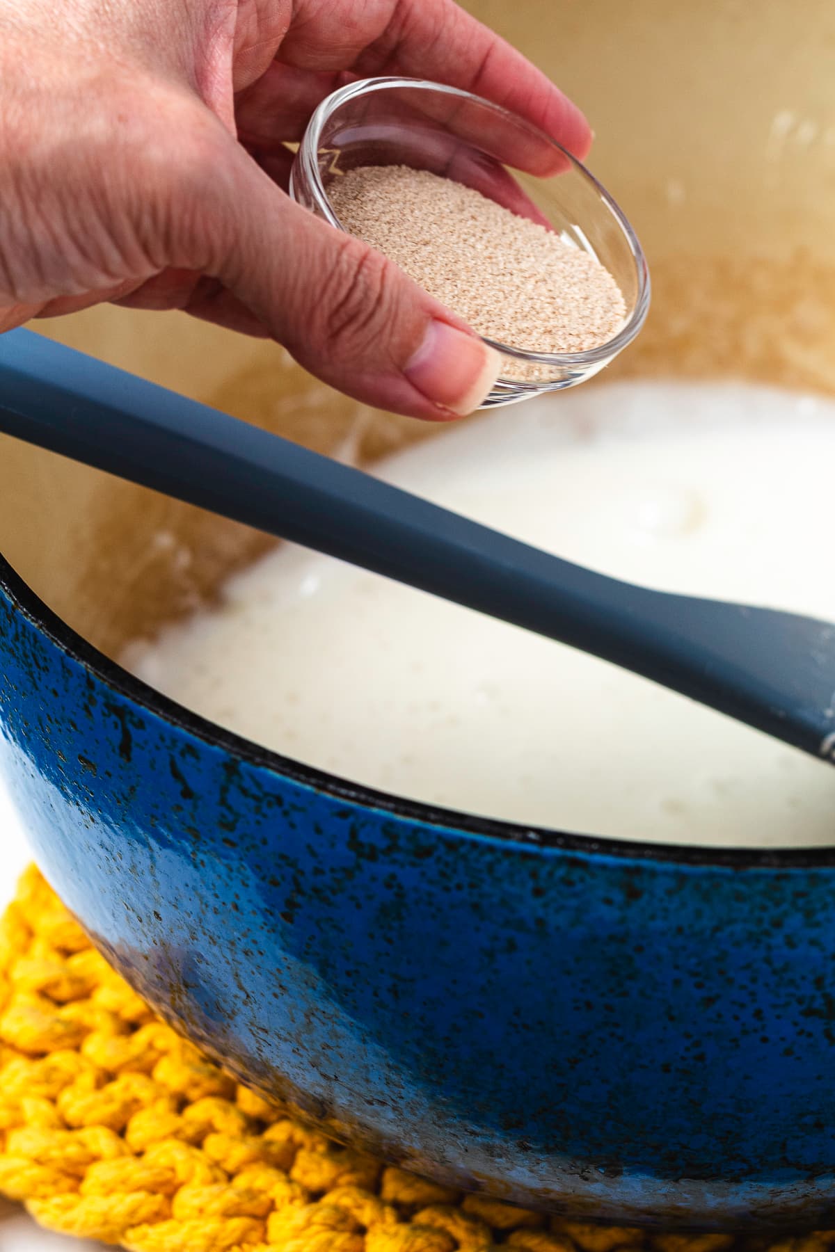 Apple cider drink mix being added to the melted marshmallow mixture for Rice Krispie treats.