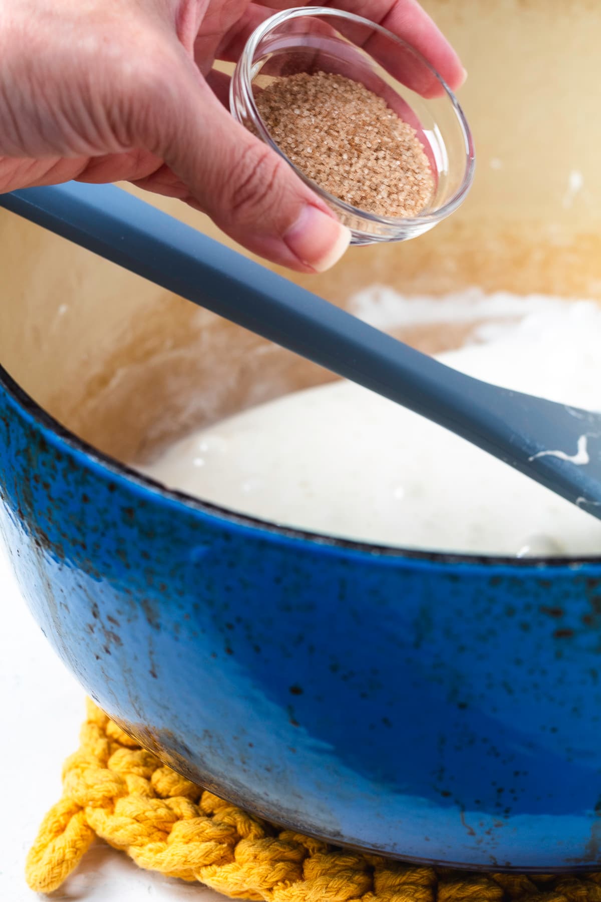 Chai spice being added to the melted marshmallow mixture.
