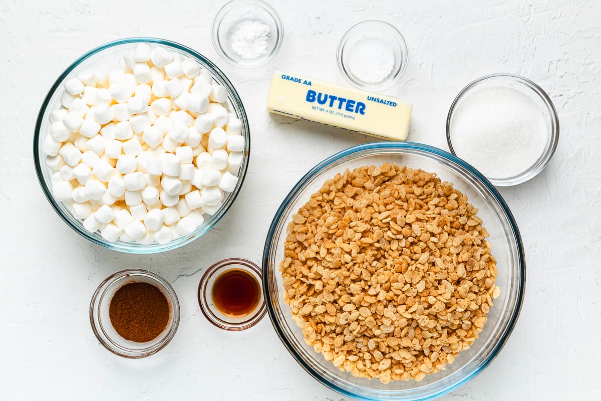 Ingredients for Snickerdoodle Rice Krispie Treats, including cereal, marshmallows, butter, sugar, cinnamon, and vanilla.