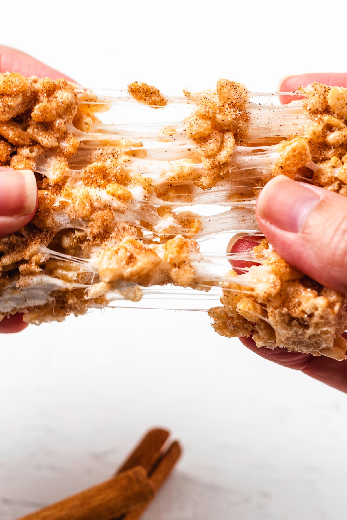 Snickerdoodle Rice Krispie Treat pulled apart to show melted marshmallow strands.