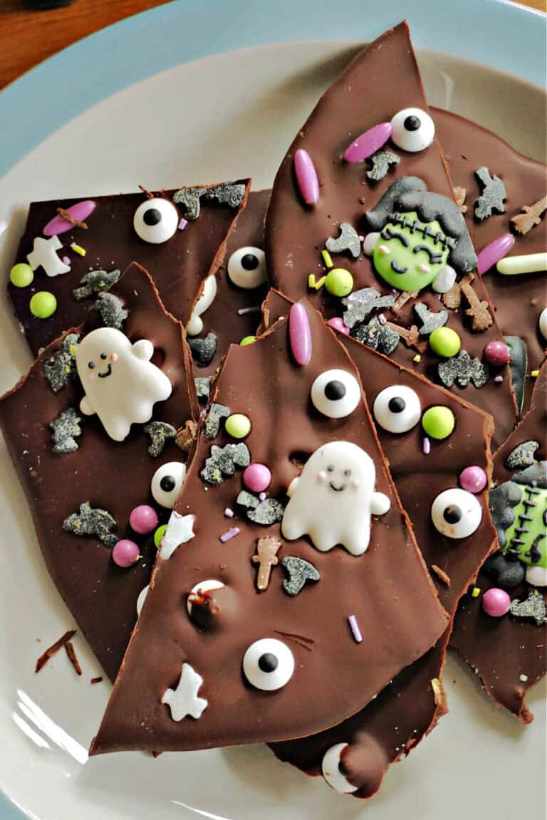Chocolate Halloween bark on a white and blue plate.