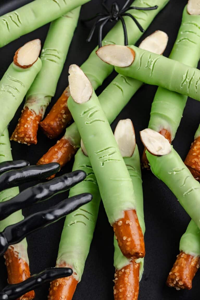 Green pretzel witch fingers on a black background.