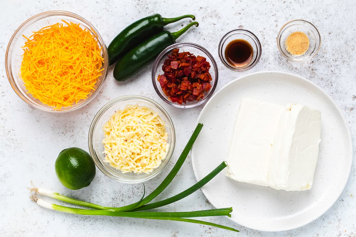 Cream cheese, cheddar, pepper jack, bacon, jalapeños, green onions, lime, and seasonings for a cheese ball.