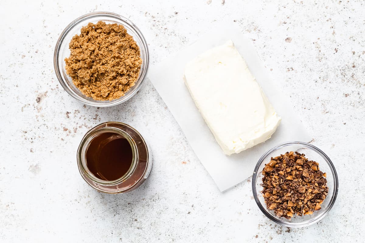 Overhead view of cream cheese, brown sugar, caramel sauce, and chopped Heath bars for caramel apple dip.