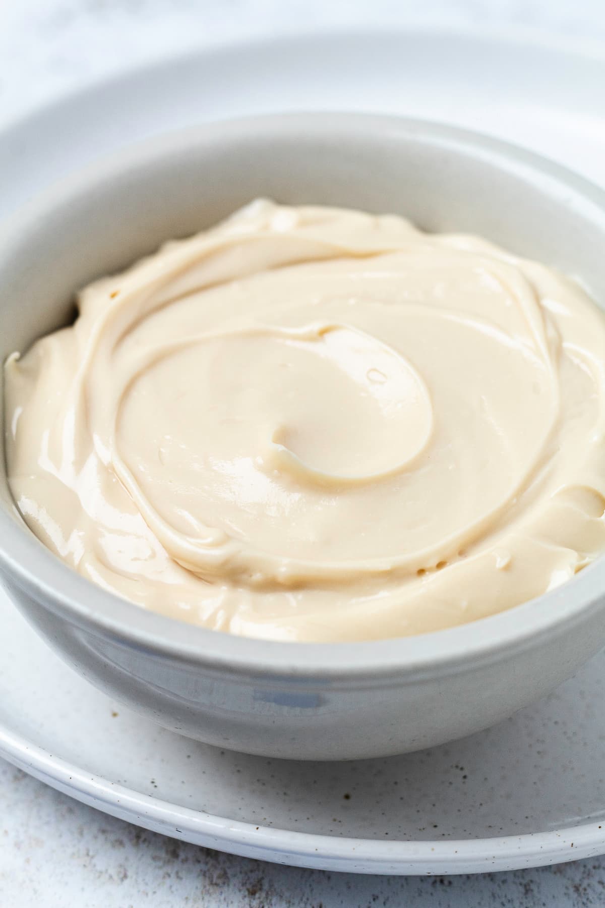 Smooth, whipped cream cheese mixture in a white bowl before adding the caramel and toffee toppings.