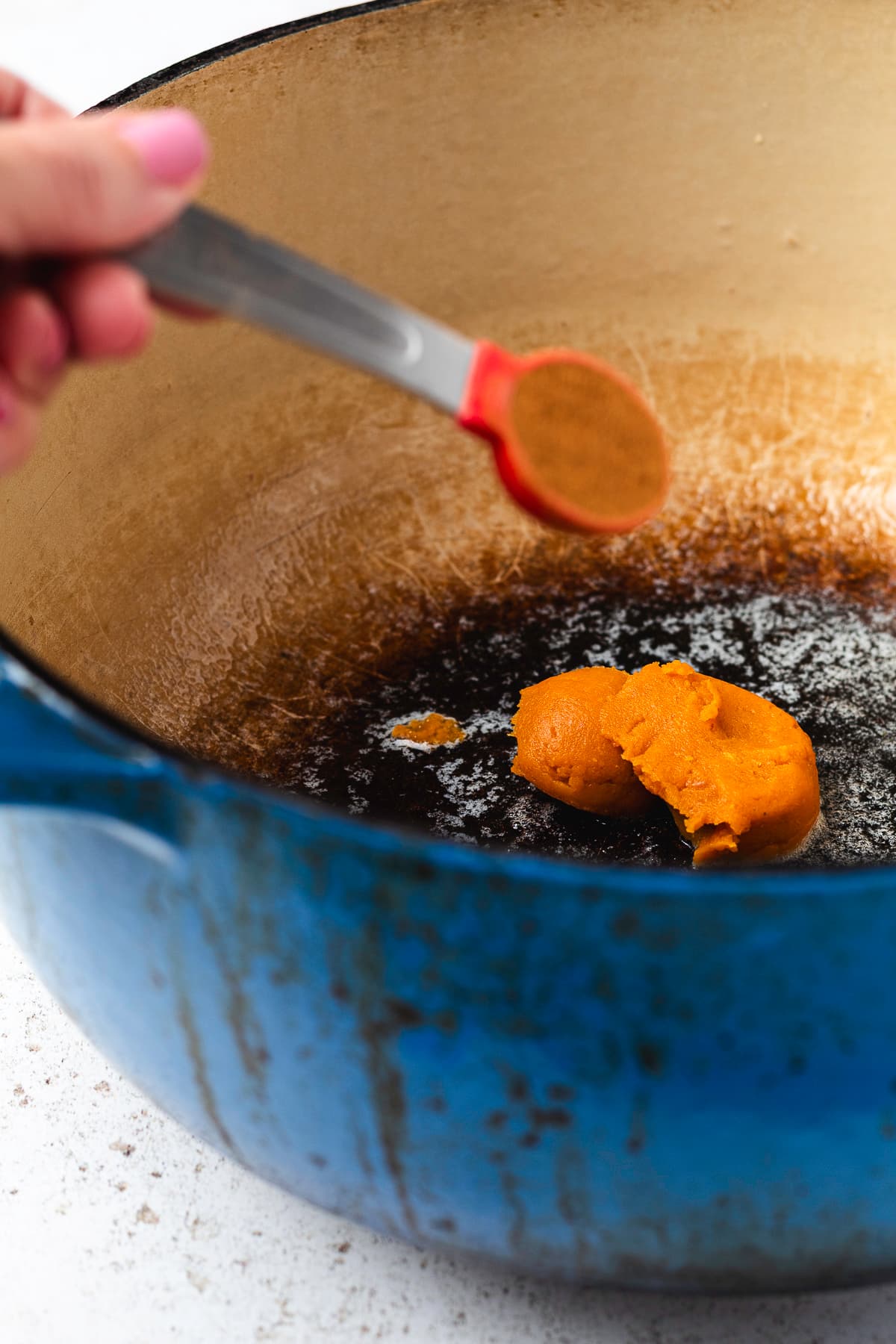 Pumpkin pie spice being added to the melted mixture.