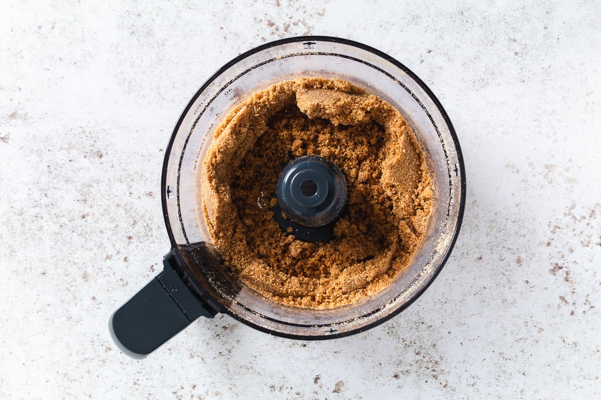 Graham cracker mixture processed into fine crumbs for mini cheesecake cups.